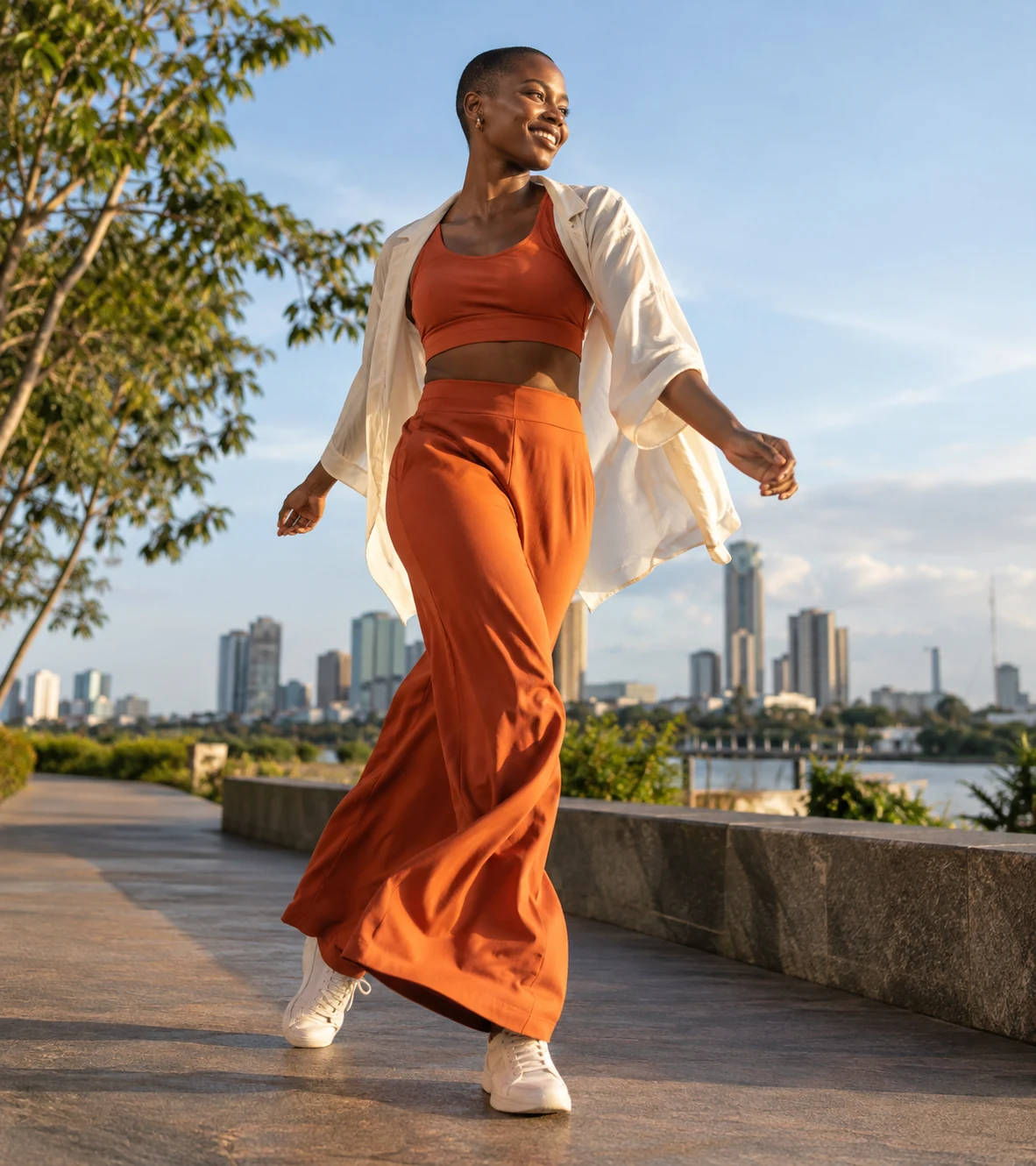 Femme souriante en marche au bord de l’eau dans un environnement urbain